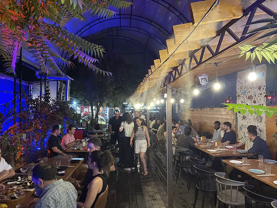 Busy covered terrace reflects Yerevan nightlife with groups dining and socializing after dark.