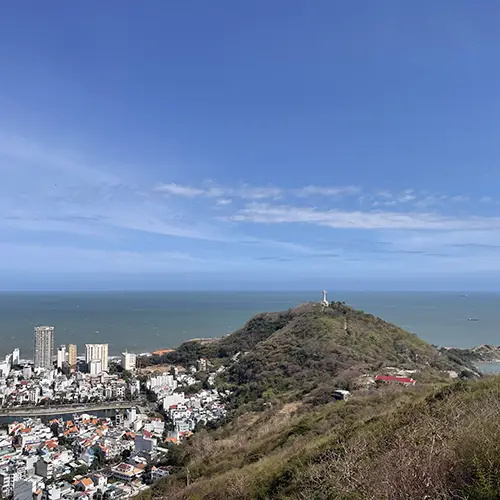 Hilltop view stretching from the lighthouse toward the distant Jesus statue.