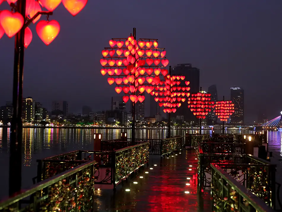 Red lanterns glowing at dusk on Love Bridge, a popular spot for couples in Da Nang