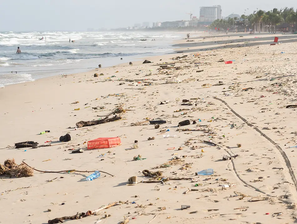 Early morning shoreline at My Khe Beach with gentle waves and scattered fishing gear.