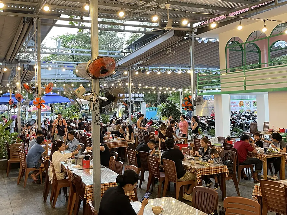 Bustling open-air seafood restaurant filled with diners enjoying fresh seafood in Vung Tau.