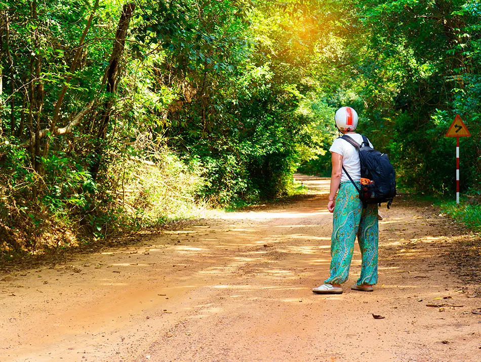 Traveler waiting for a motorbike taxi on a rural road