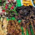 A street stall displaying assorted grilled meats and organs, showcasing weird food in Vietnam.