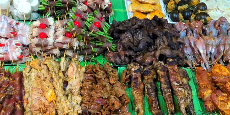 A street stall displaying assorted grilled meats and organs, showcasing weird food in Vietnam.