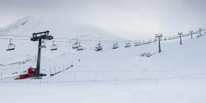 Empty chairlift line in falling snow captures the mood of underrated ski resorts in winter storms.