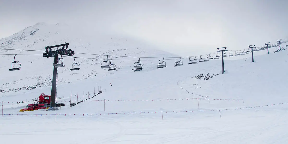 Empty chairlift line in falling snow captures the mood of underrated ski resorts in winter storms.