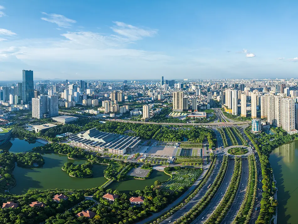 Aerial view of Hanoi with modern towers, green parks, and a winding river.
