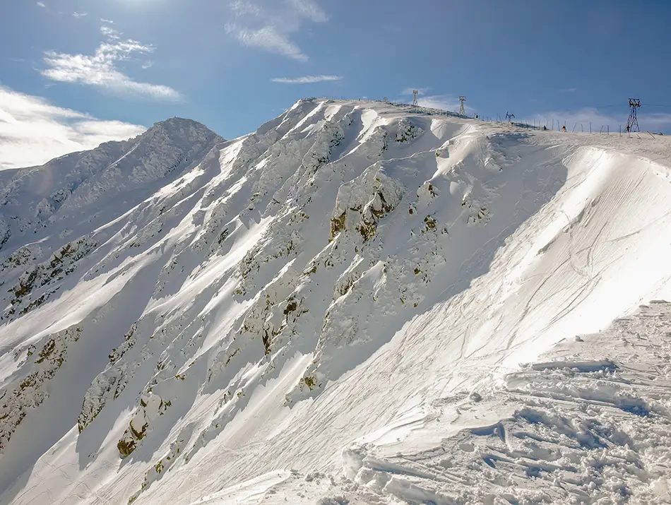 Wind-scoured ridgeline shows steep bowls and cornices after a big snowfall.