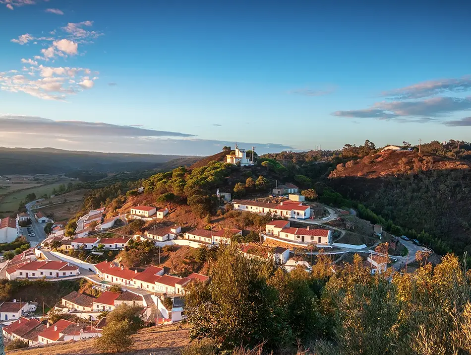 Hilltop view of Aljezur old town surrounded by green valleys in Algarve.