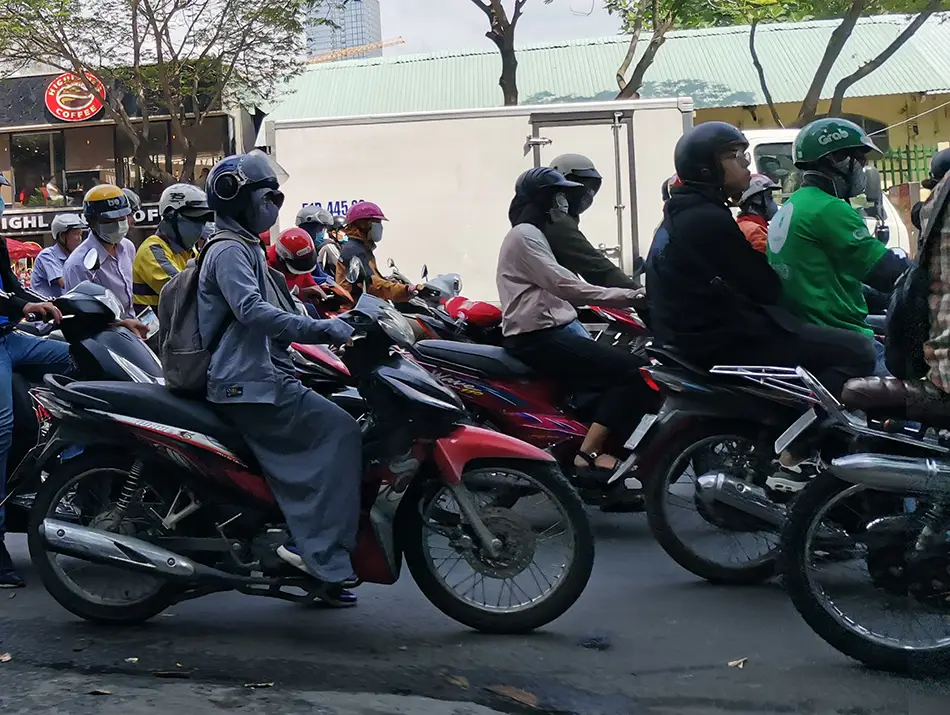 Dense motorbike traffic fills a city street, capturing daily movement and urban rhythm in Ho Chi Minh.