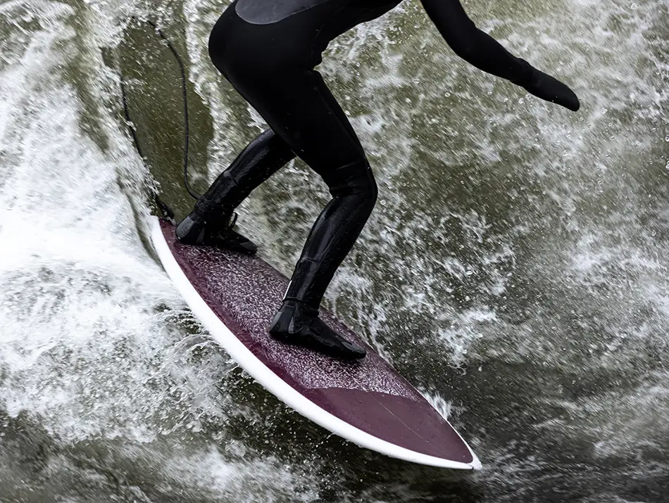Cold-water surfer on a choppy wave at Hoddevik, Norway, in a wetsuit.