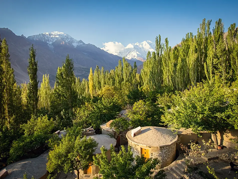 Hunza Valley lodge with pine slopes, lesser known hiking trails start nearby.