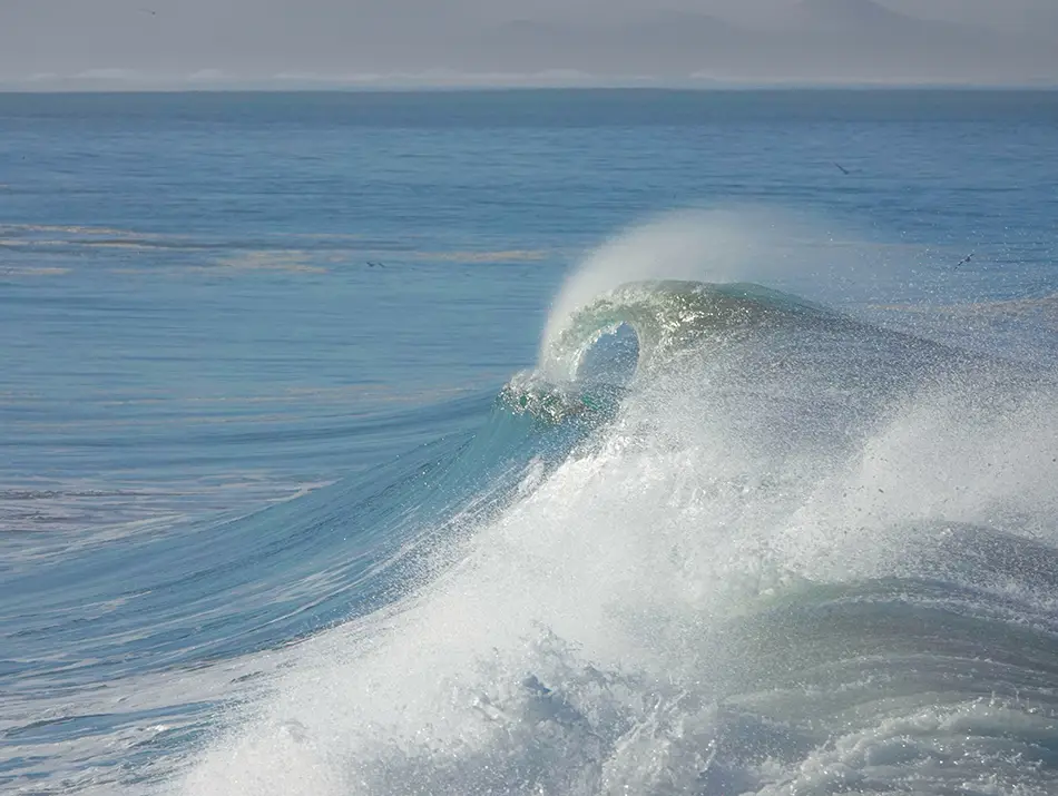 Glassy wave peeling at Imsouane, Morocco, a long right-hand point break.