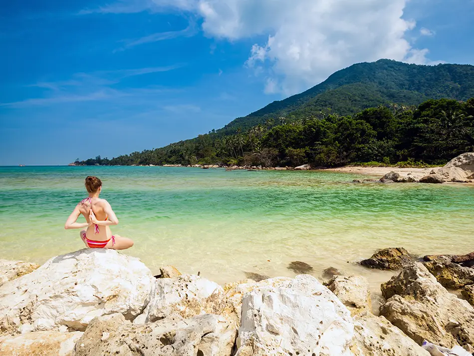 Solo yoga practice on a quiet sandy beach in Koh Phangan, Thailand.