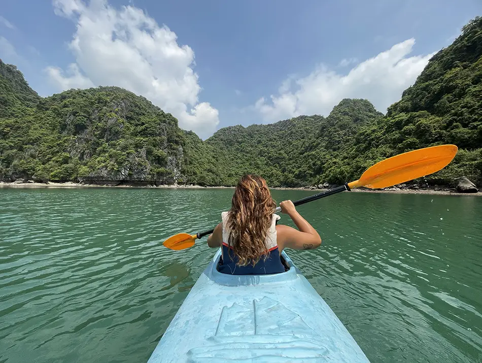Kayaker paddles through Lan Ha Bay karst islands, one of the unique things to do in Vietnam.