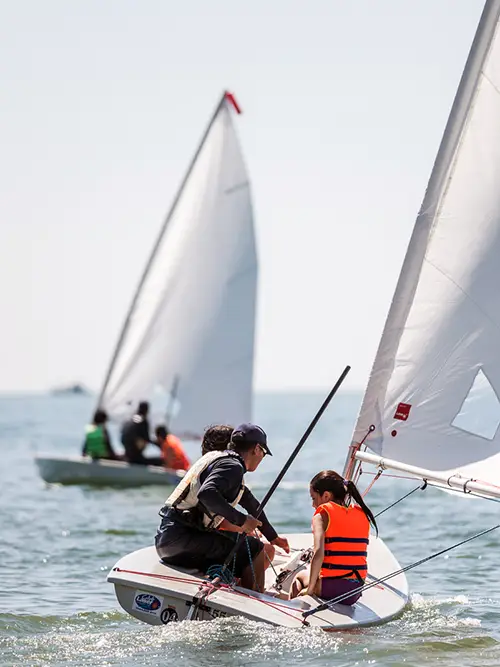 Instructor guiding a child during sailing classes in Mui Ne Bay.