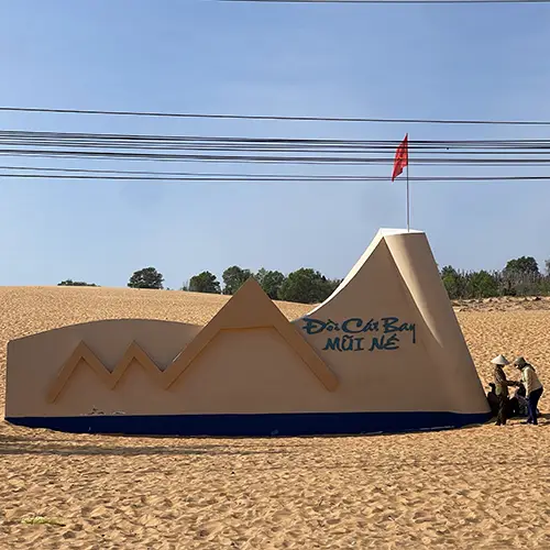 Smooth red sand dune ridge under open sky, shaped by wind and coastal climate.