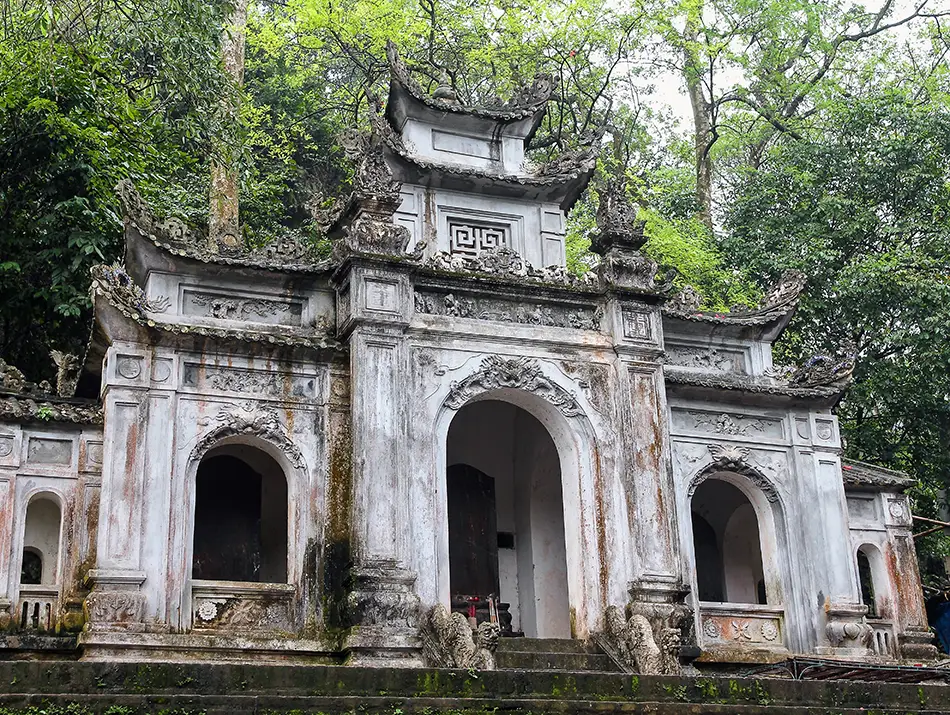 Historic stone gate surrounded by trees marking one of the top attractions in hanoi.