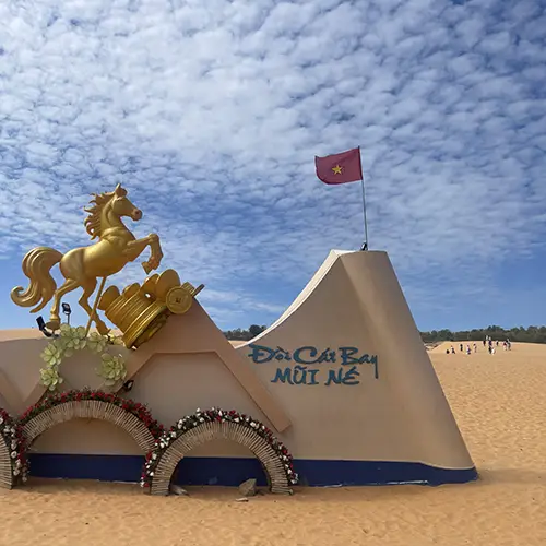 Smooth red sand dune ridge under open sky, shaped by wind and coastal climate.