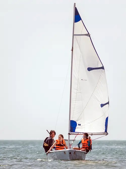 Two tourists sailing a small dinghy during sailing classes in Mui Ne Bay.