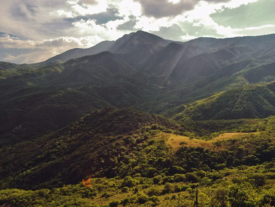 Sunlit mountain valley with cloud shadows, ideal for a long ridge hike.