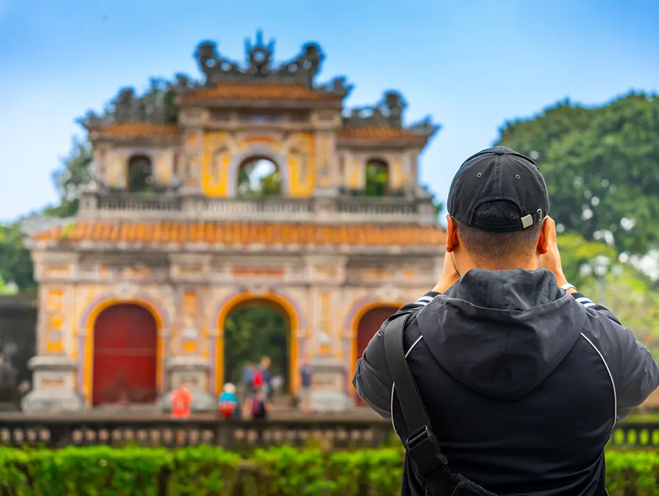 Traveler photographing an ornate imperial gate