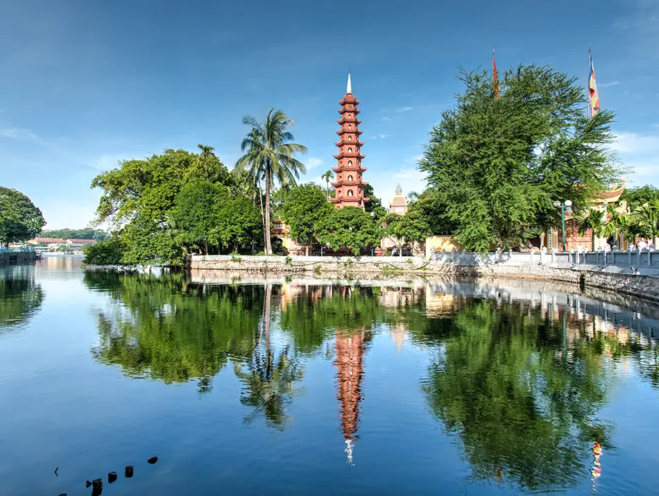 Tall red pagoda beside the lake, considered one of the must-do in hanoi landmarks.
