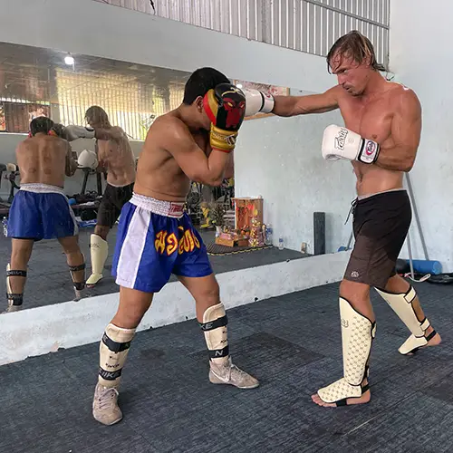 Traveler learning Muay Thai with a local instructor during a training session in Mui Ne.