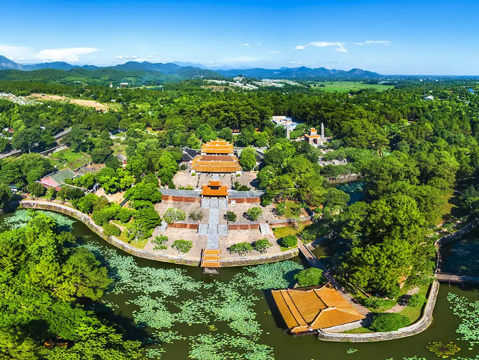 Ornate pavilion set among trees and ponds within a serene royal burial ground.
