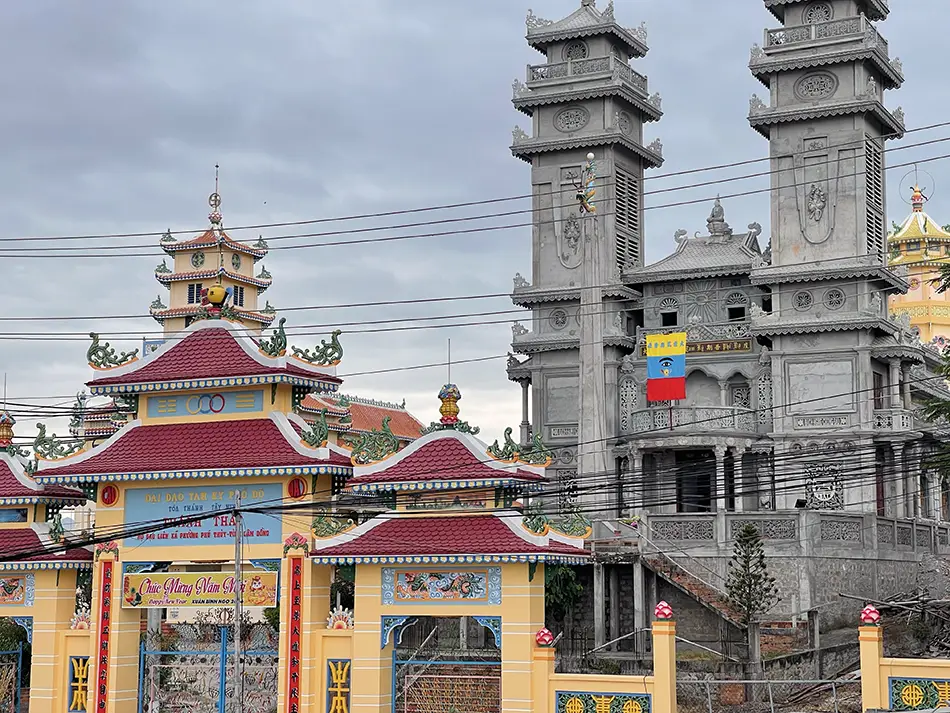 Cao Dai temple facade with twin towers and colorful roof details.