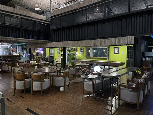 Indoor dining area with wooden floors and neatly arranged tables and chairs.