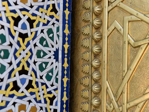 Colorful geometric tile mosaic and carved plaster near the royal gates.