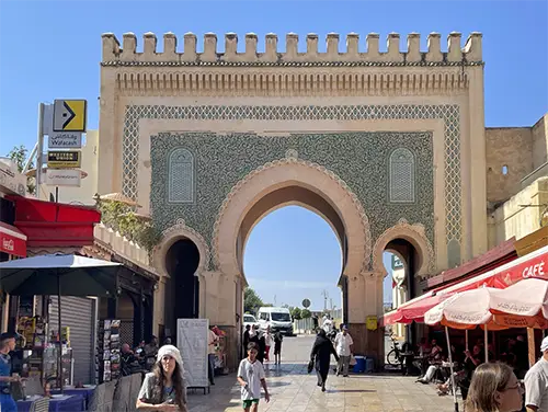Inner horseshoe arch with intricate tilework and carved cedar details.