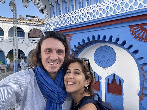 Travelers posing in a blue courtyard in Chefchaouen.
