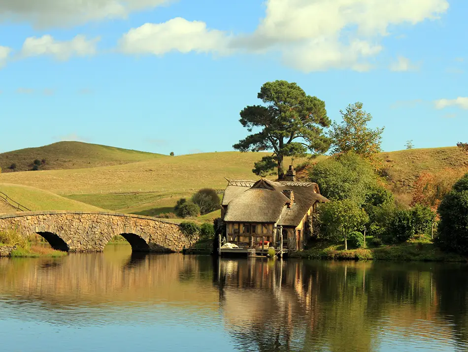 Peaceful lake and rolling hills at Hobbiton Movie Set in New Zealand.