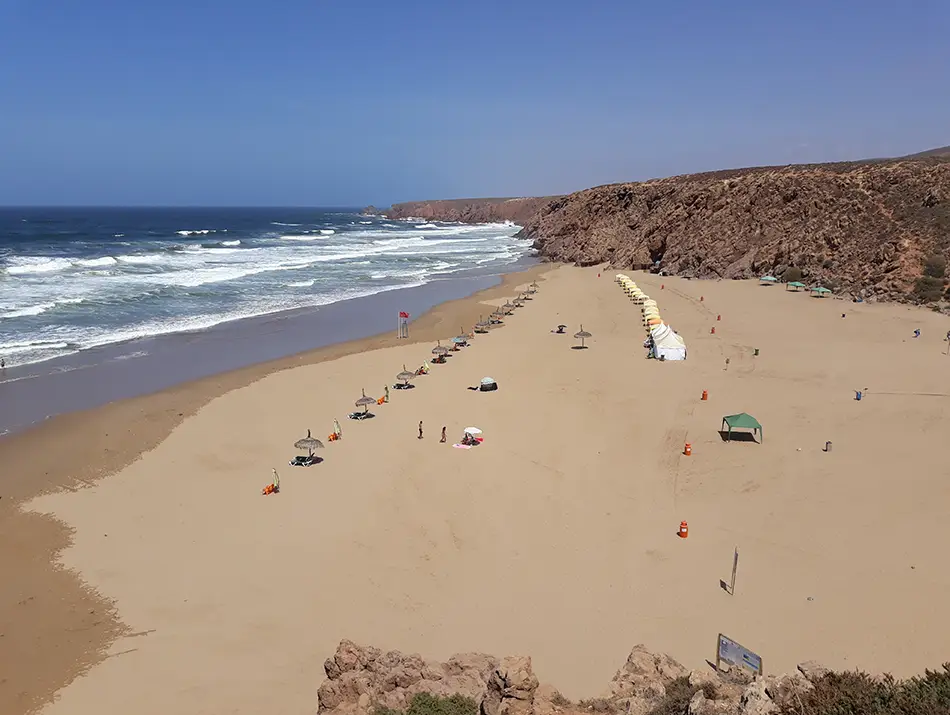 People relaxing on the wide sandy expanse of Imin Turga beach
