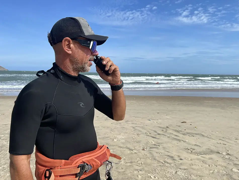 Instructor from kitesurfing school in Mui Ne checks radio and watches the shoreline.