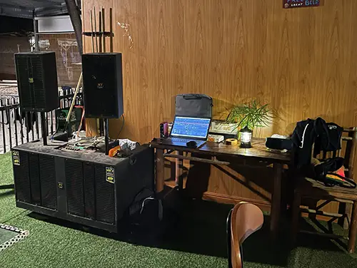 Compact DJ desk with speakers and laptop inside The King Bar venue.