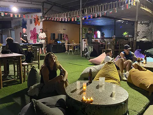 Guests relaxing around a low table by the beach, typical part of Mui Ne Nightlife.
