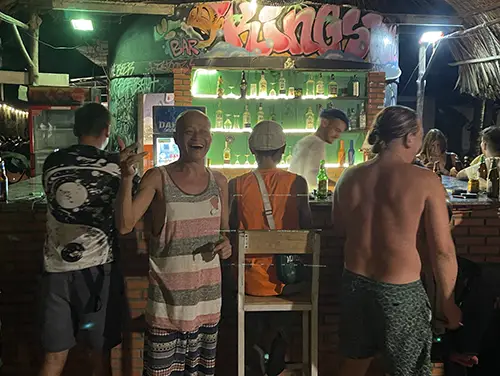 Travelers standing and talking near the bar counter at Kingston Hut in Mui Ne.