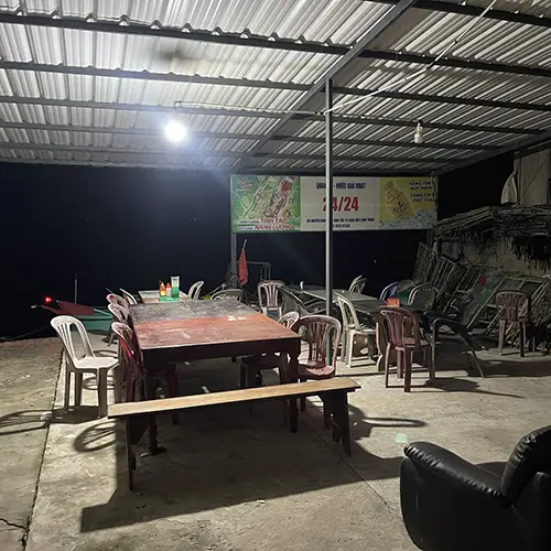 Covered open-air dining space with wooden tables and casual seating.