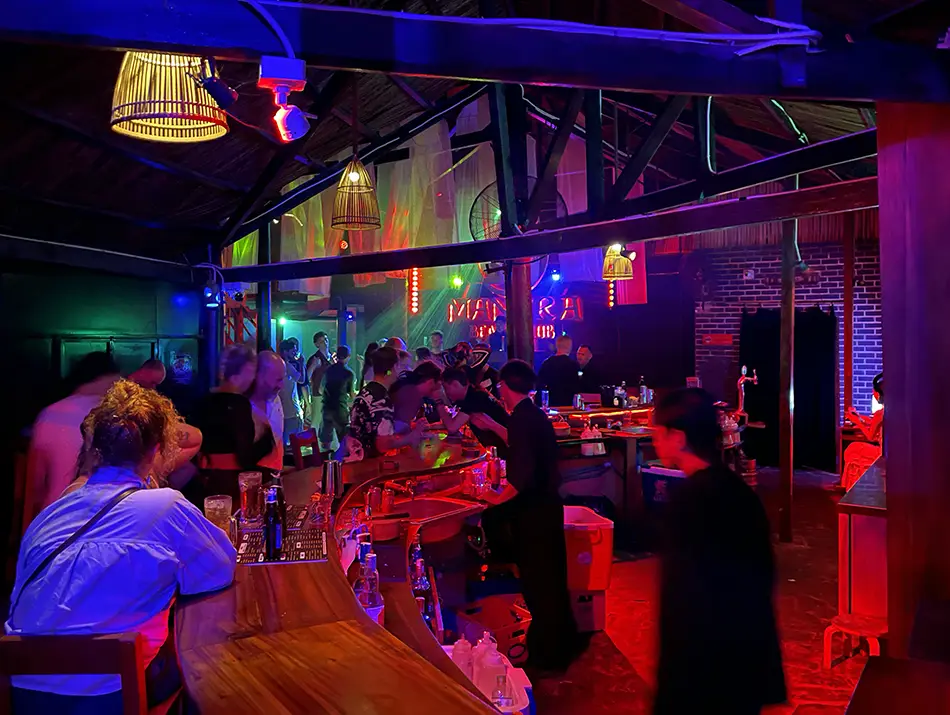 Bartender preparing drinks behind a glowing counter at a beach bar in mui ne.