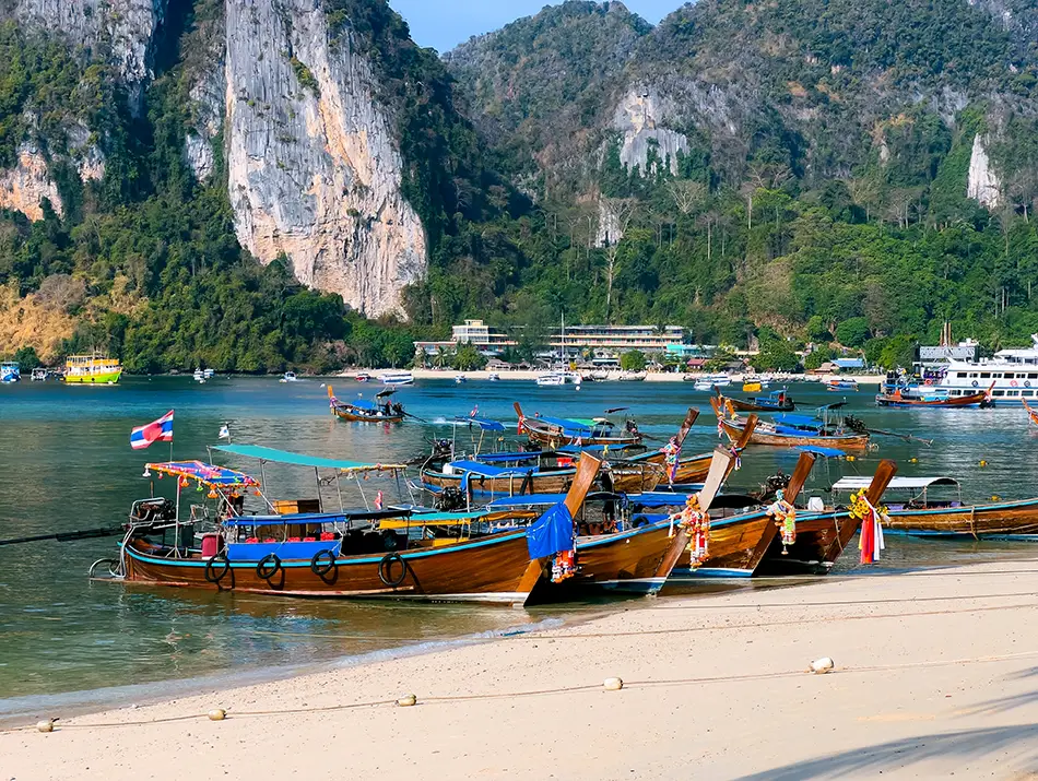 Traditional longtail boats anchored at Maya Bay, one of the best movie locations for travelers.