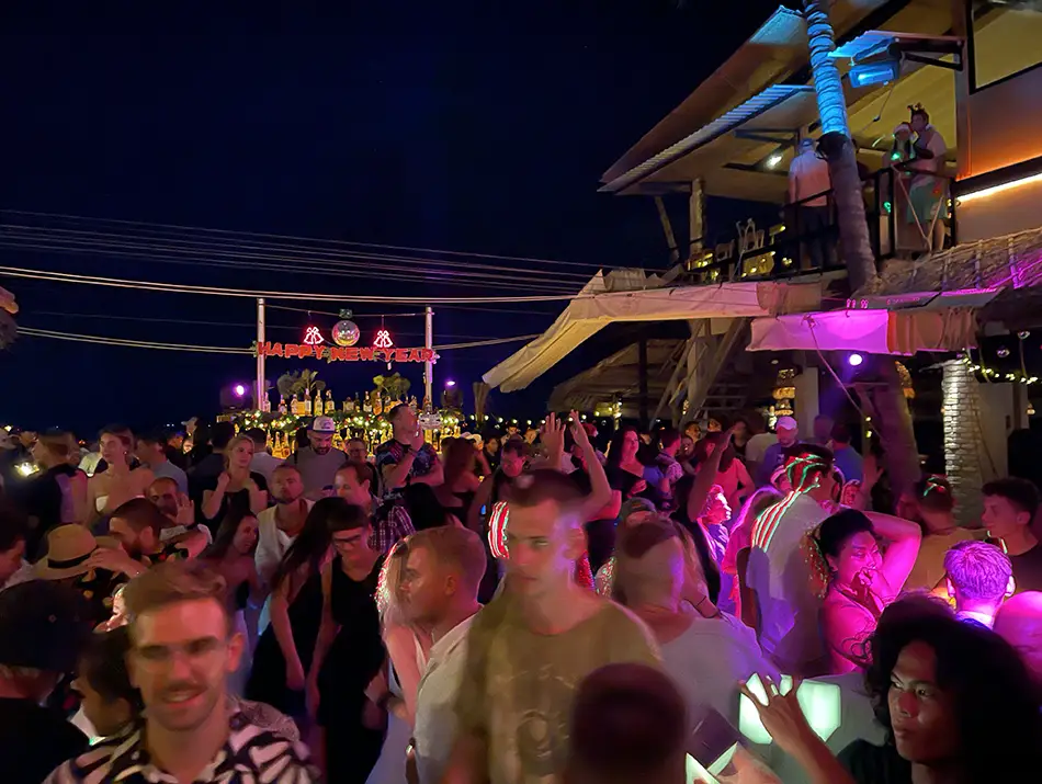 Crowd dancing under colorful stage lights inside Nirwana, a highlight of Mui Ne Nightlife.
