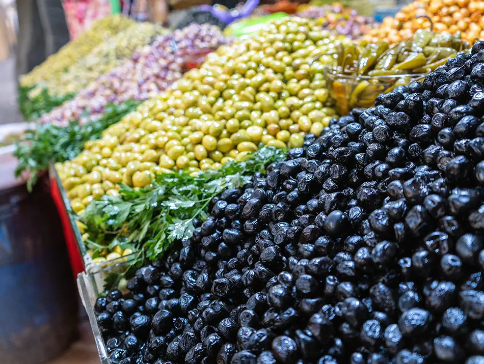 Olive stalls in medina market, showing everyday activities in Meknes.