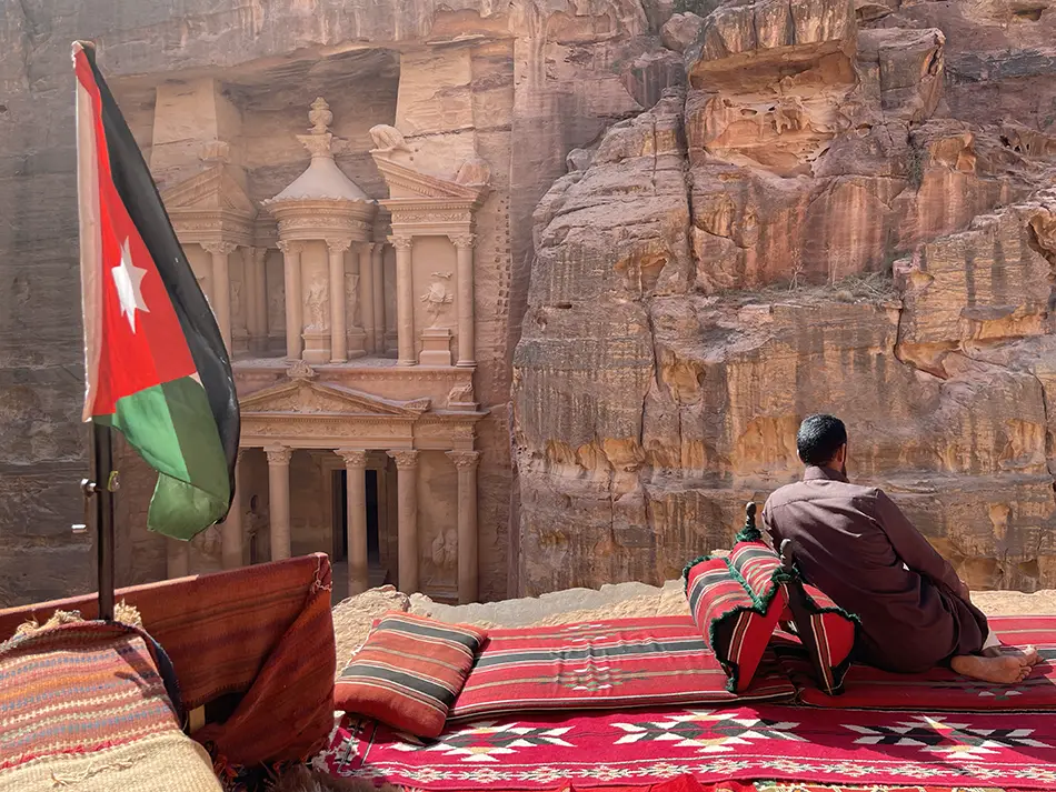 Man seated in front of Petra’s Treasury, a popular for Movie Pilgrimage destination.