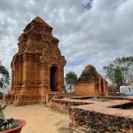 Wide view of Cham towers near Mui Ne with courtyard and surrounding trees.