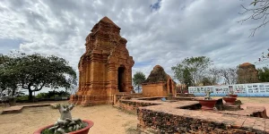 Wide view of Cham towers near Mui Ne with courtyard and surrounding trees.