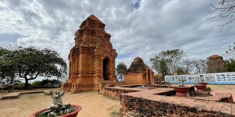 Wide view of Cham towers near Mui Ne with courtyard and surrounding trees.