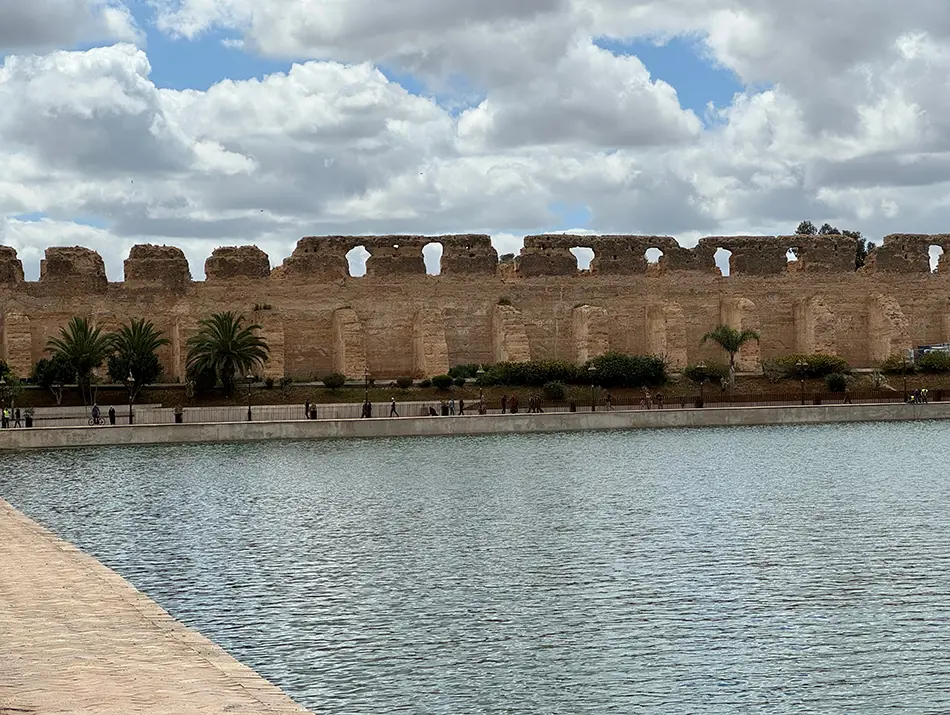 Sahrij Swani reservoir in Meknes bordered by fortified walls and calm water.